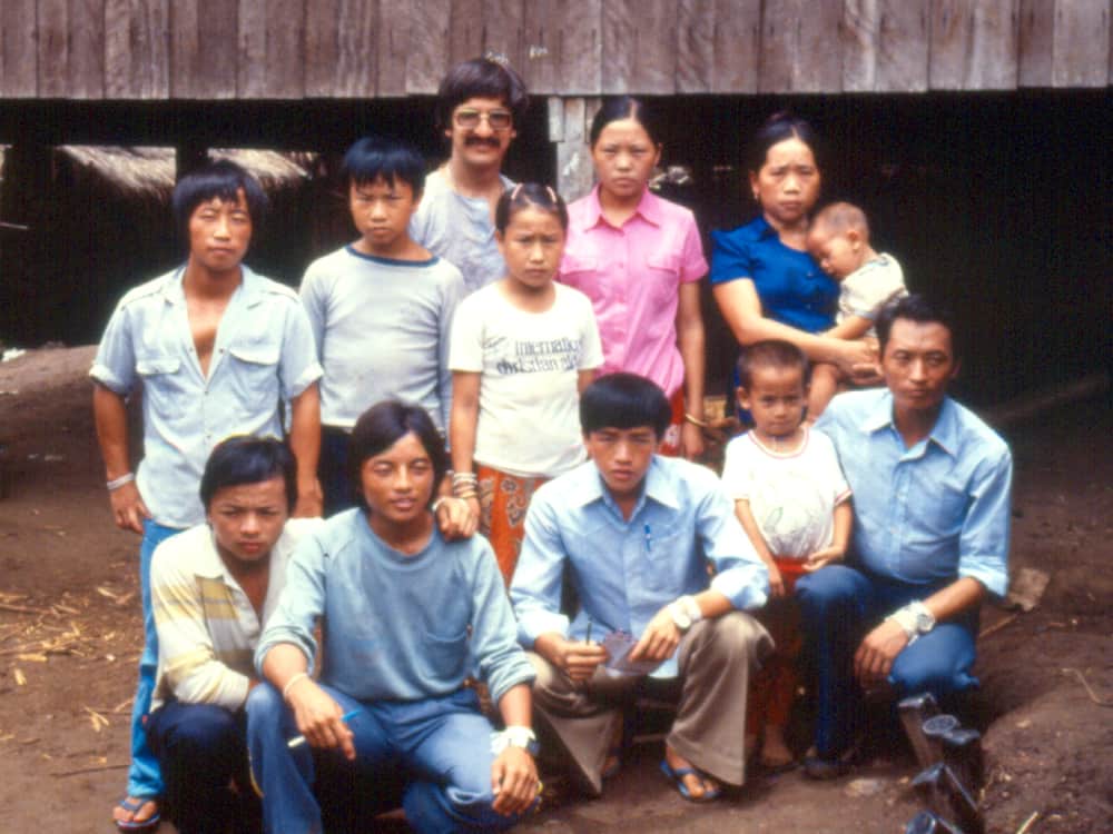 Three generations of one Hmong family photographed together outside their house at Ban Vinai