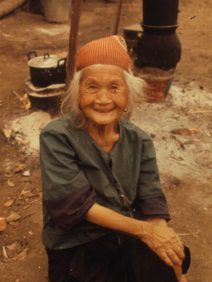 An elderly Hmong woman smiling at the camera